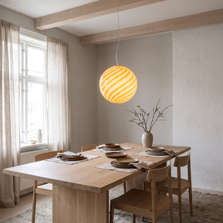 Ribbon swirl glass globe pendant light in a Scandinavian dining room