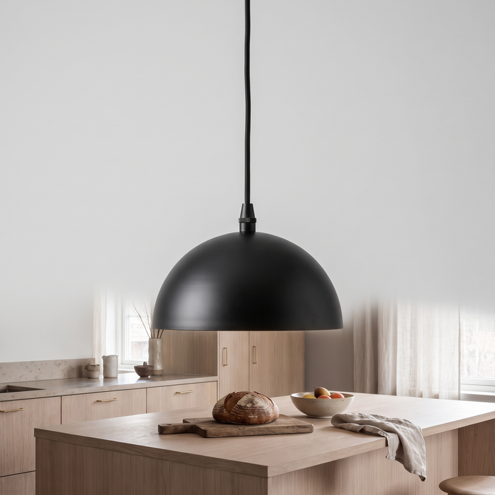 Matte black and opal glass Anvil globe pendant on a light grey background