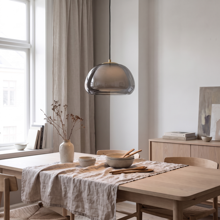 Smoked grey Drop glass globe pendant above an oak dining table