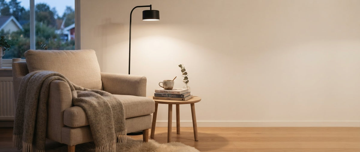 Warm reading corner at dusk with a black floor lamp beside a linen armchair